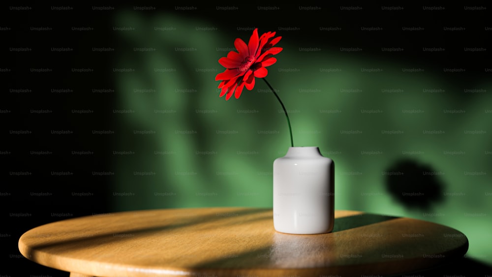 un petit vase blanc avec une fleur rouge dedans