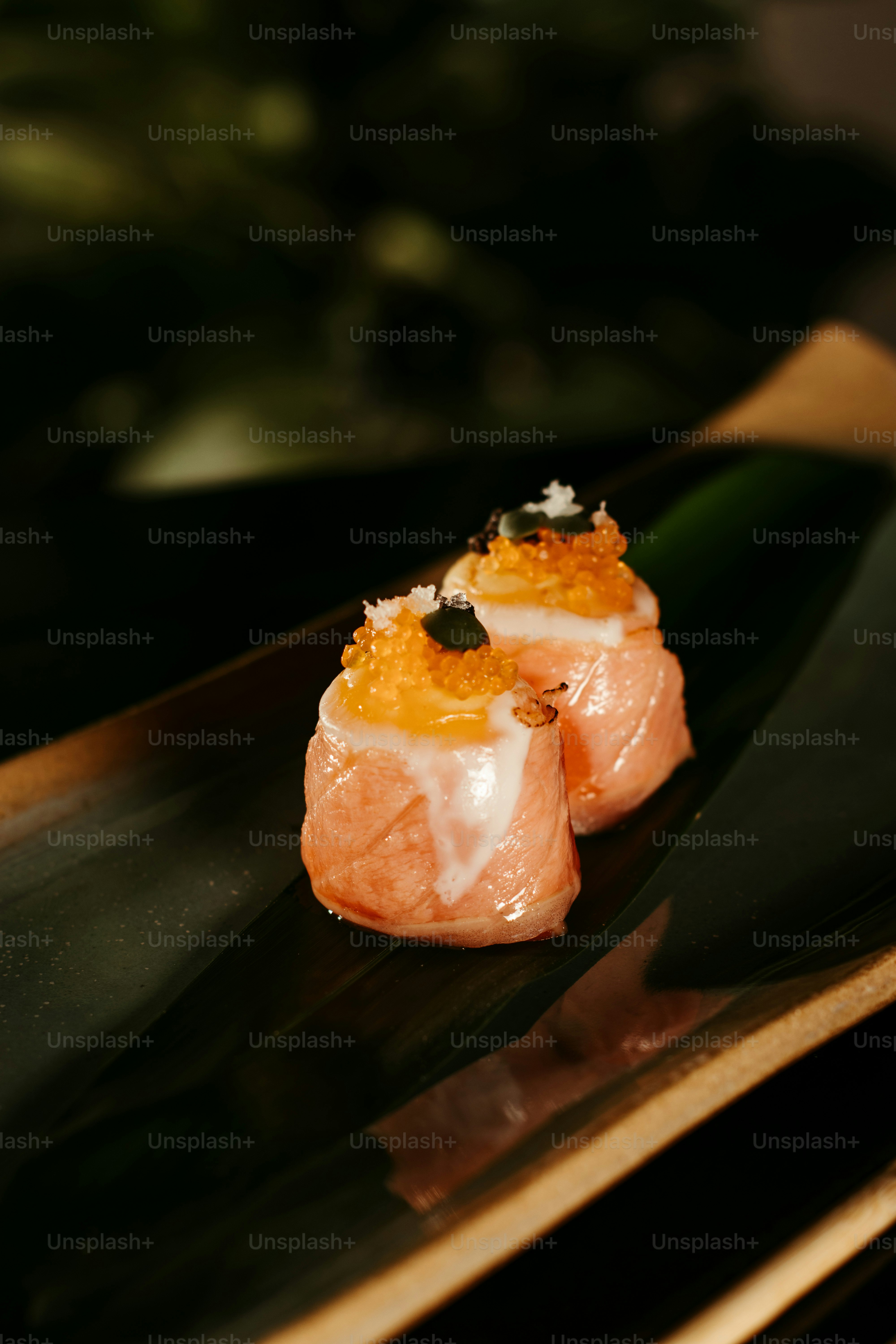 two pieces of sushi sitting on top of a black plate
