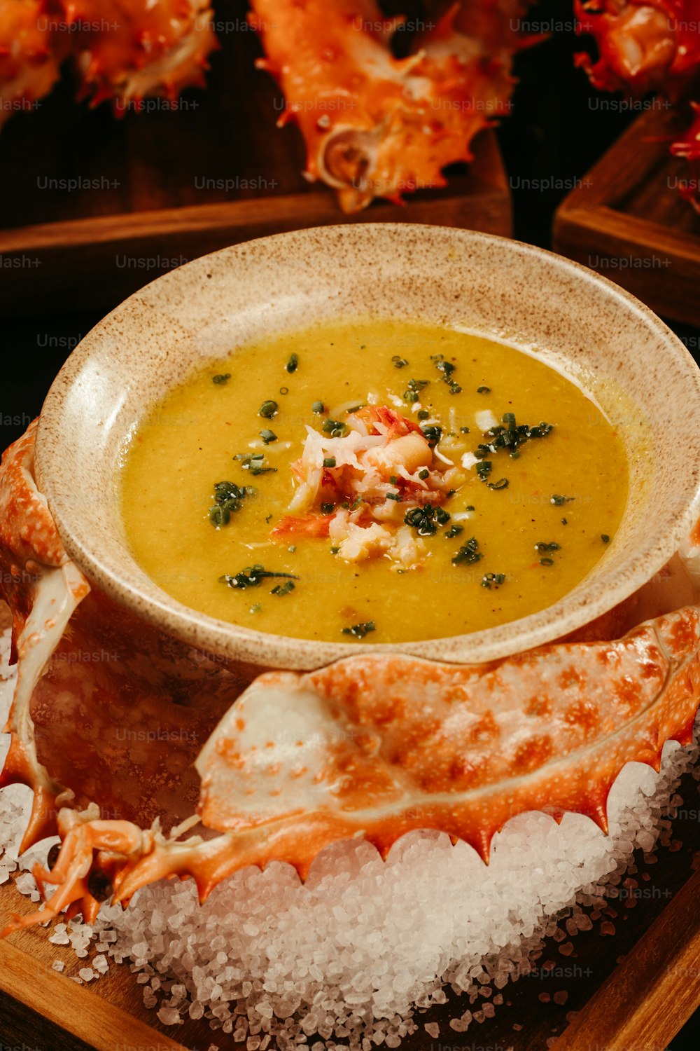a bowl of soup with crab legs on a tray