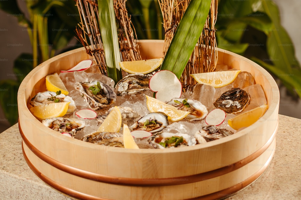 a wooden bowl filled with oysters and lemon wedges