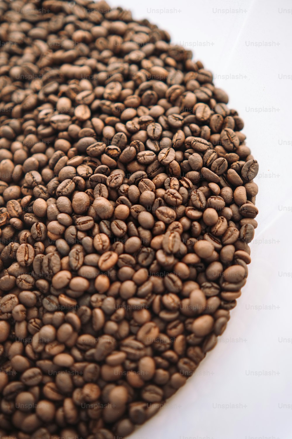 a pile of coffee beans sitting on top of a white table