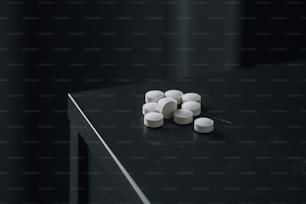 a black table topped with white pills on top of it