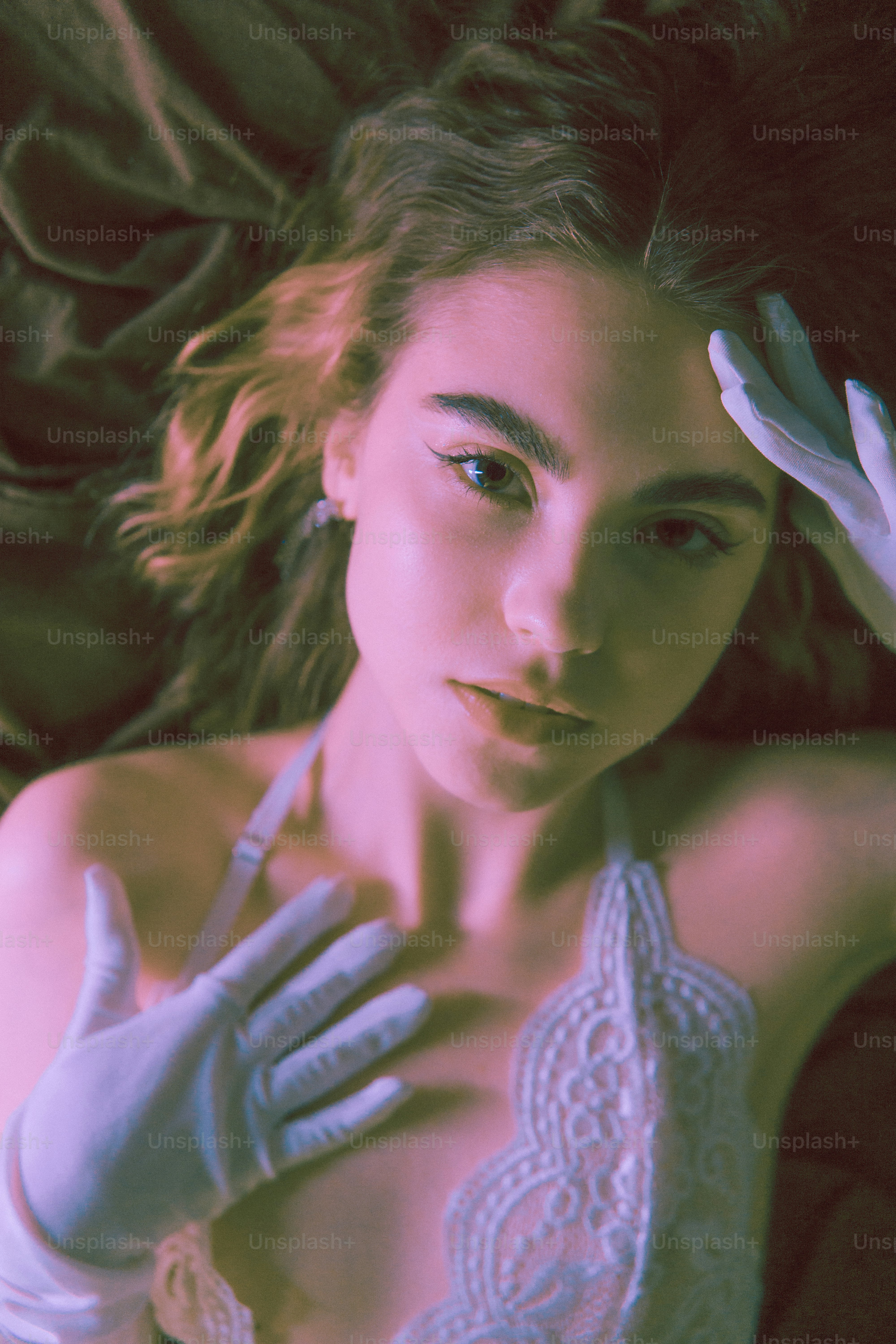 a woman with gloves on her head laying on a couch