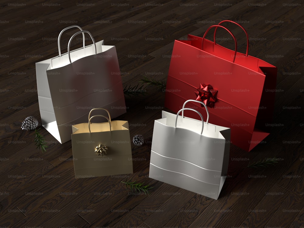 three different colored shopping bags on a wooden floor
