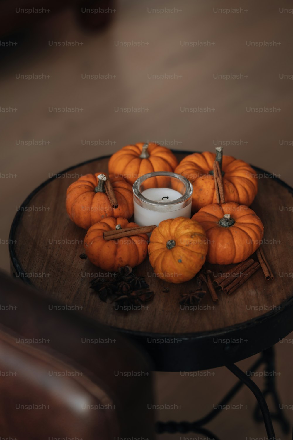 a table topped with a candle and lots of pumpkins