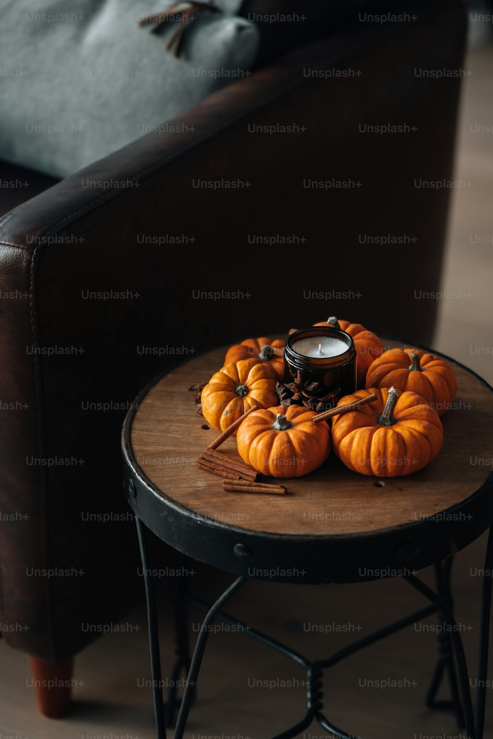 a table with a candle and pumpkins on it