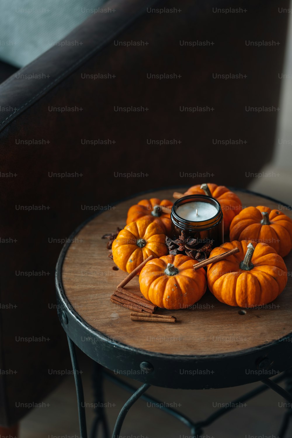 a table with a candle and some pumpkins on it