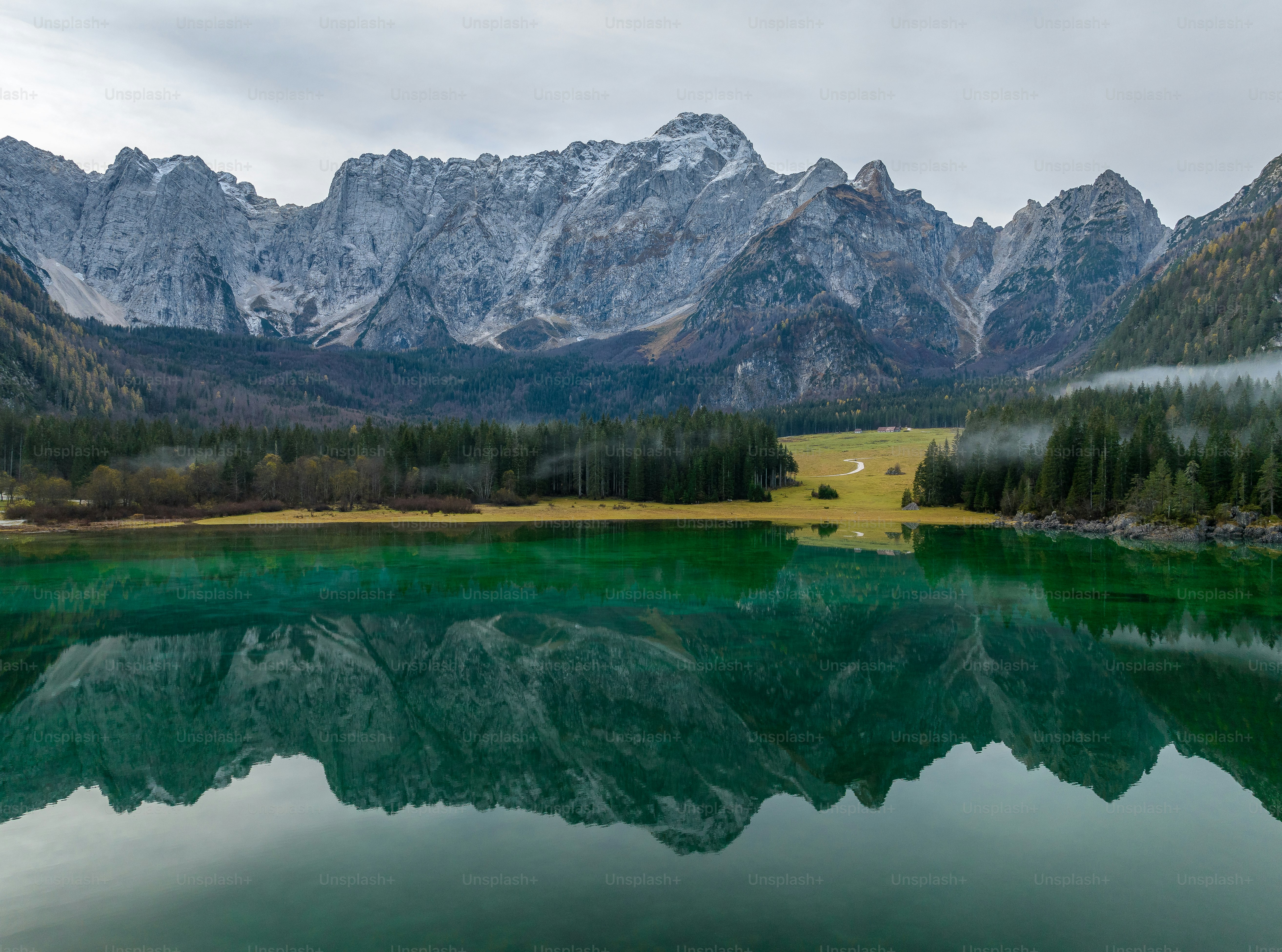 a mountain range is reflected in the still water of a lake