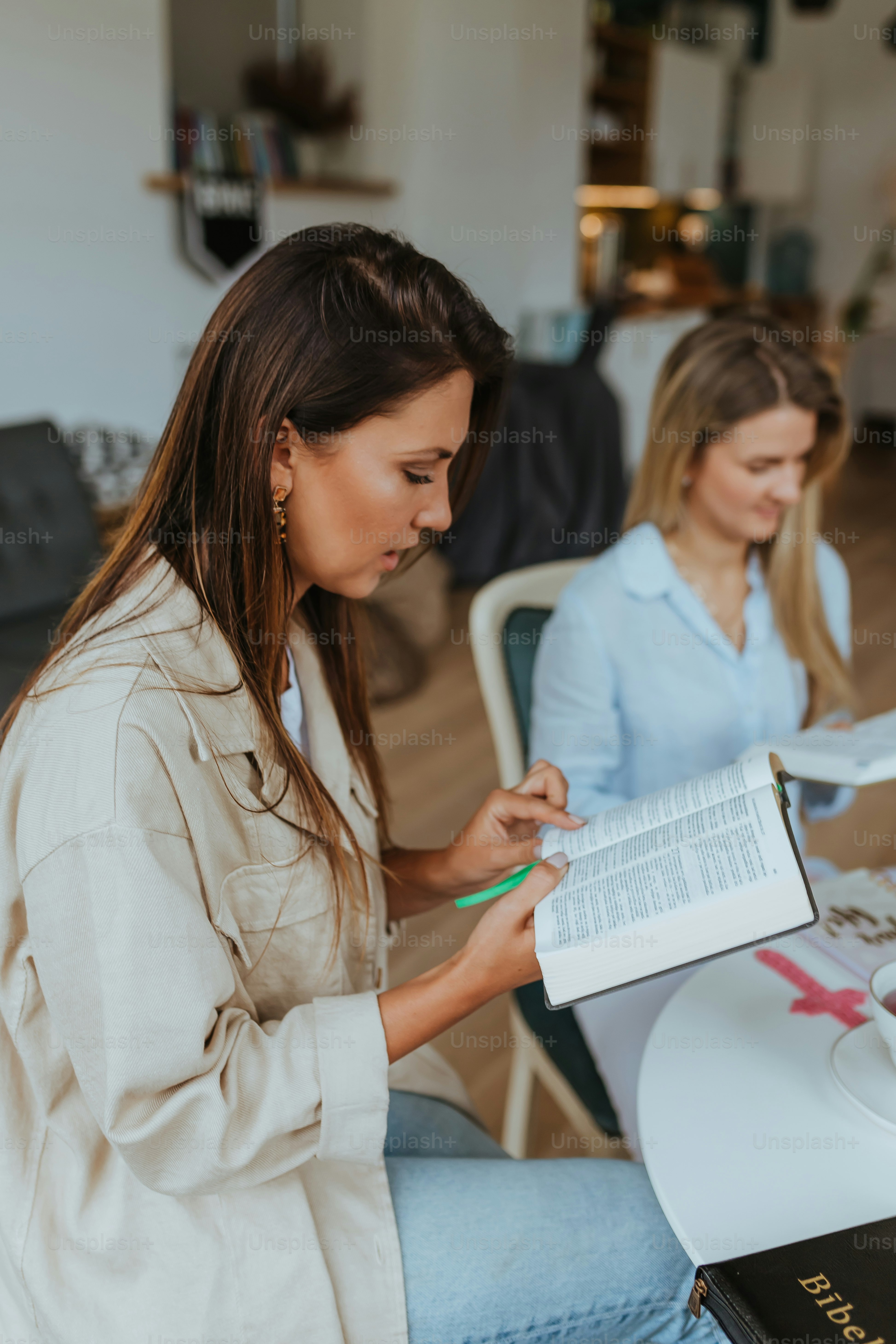 a woman showing a woman something on the paper
