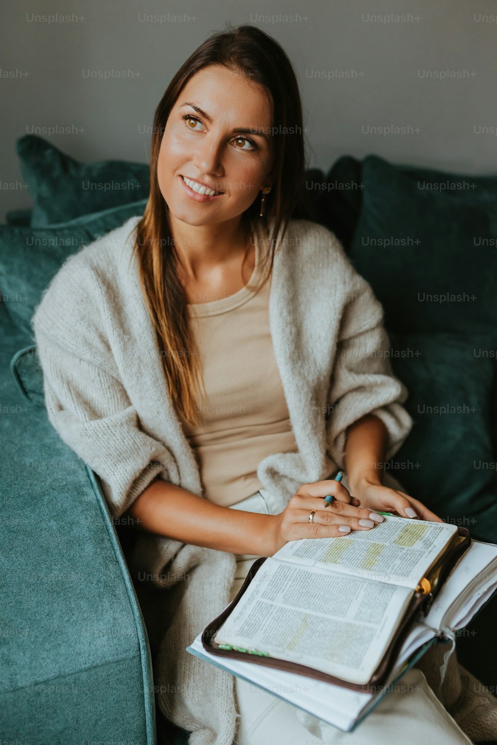 a woman sitting on a couch and reading a book