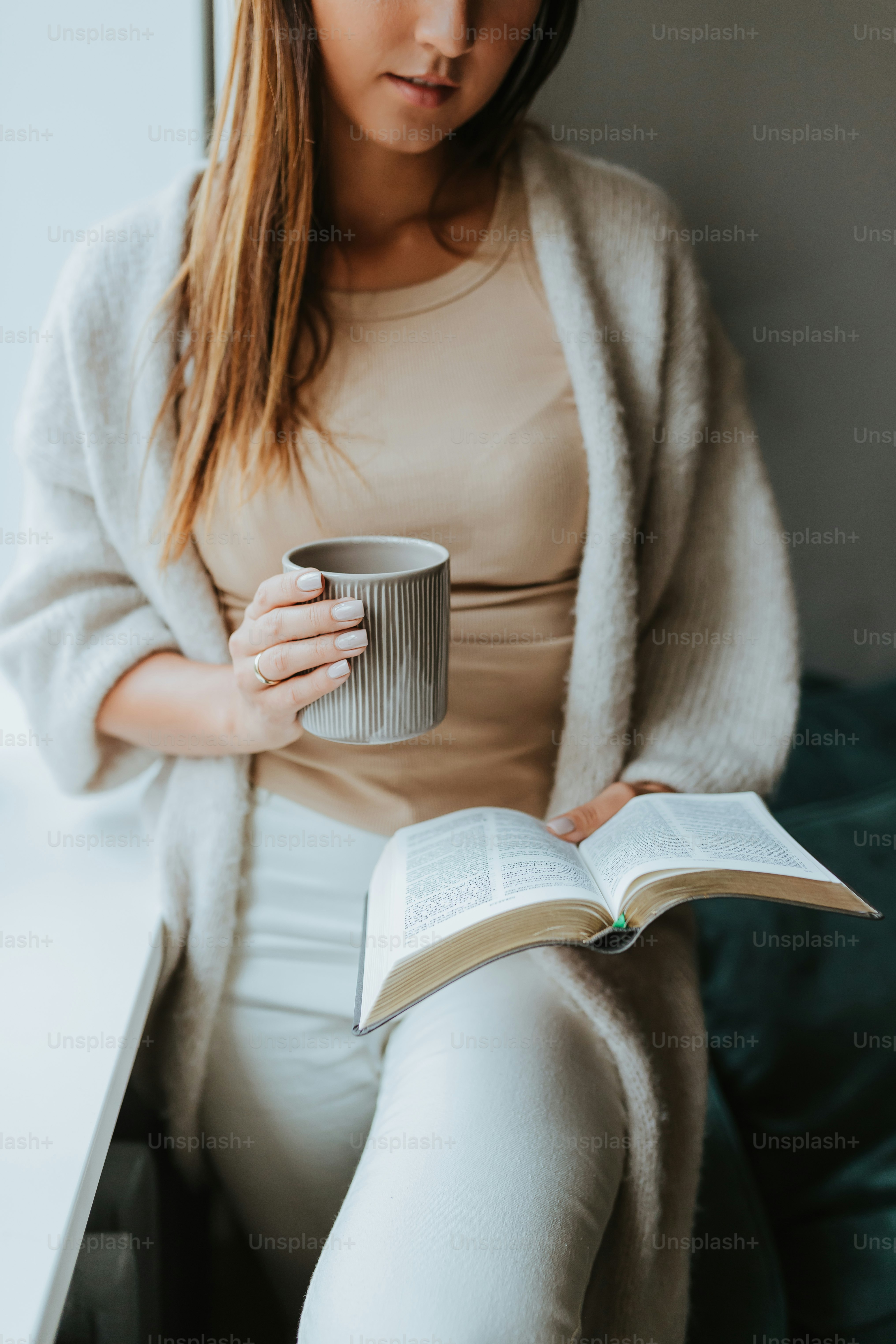 Une femme tenant une tasse et un livre