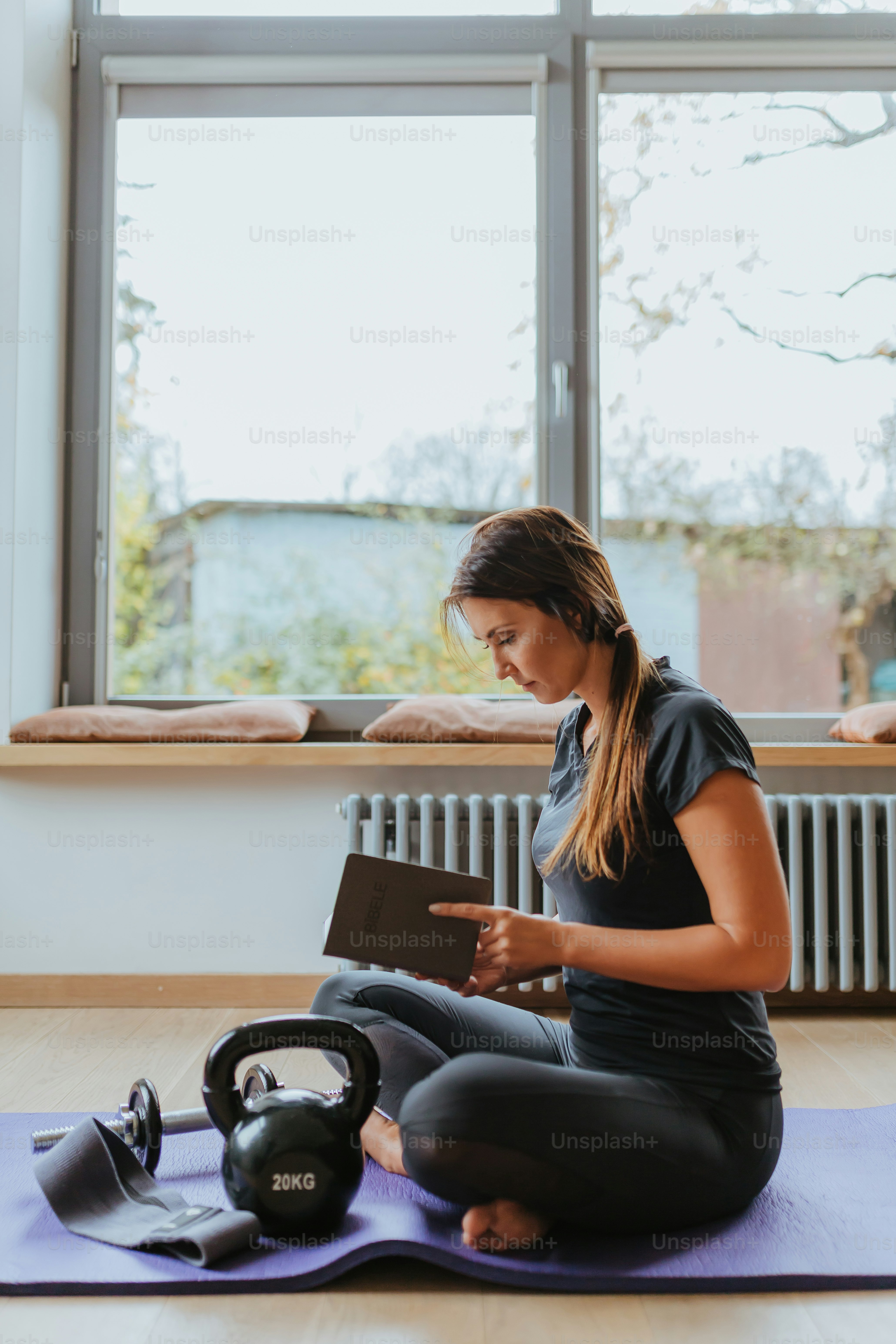 une femme assise par terre en train de lire un livre