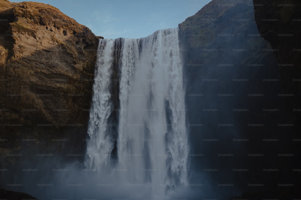 Una grande cascata con acqua che scende lungo i suoi lati