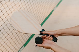 a woman is holding a paddle and a ball