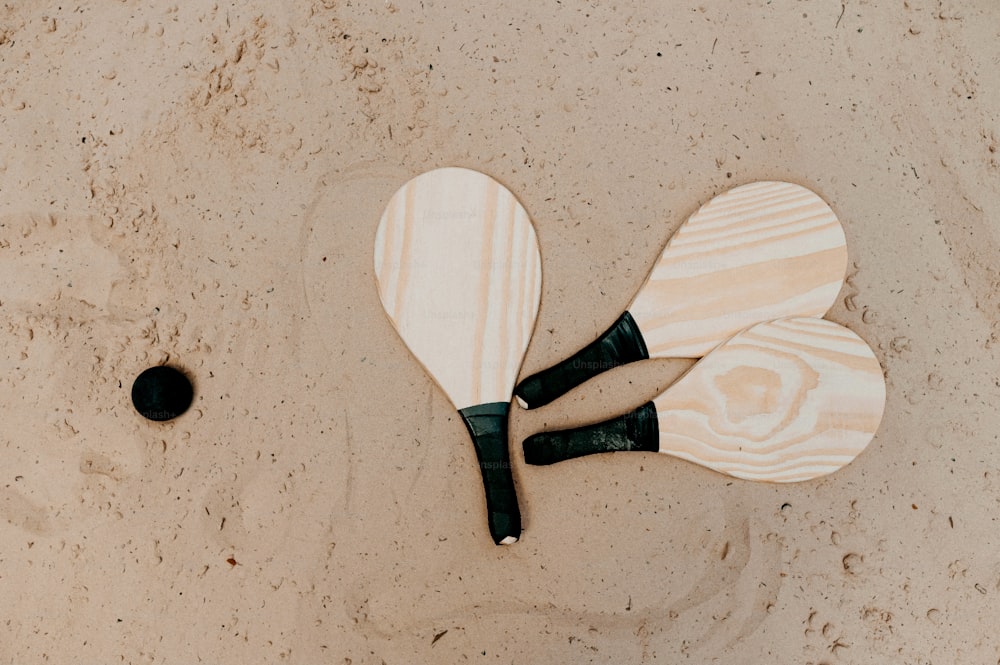 Ein paar Paddel liegen auf einem Sandstrand