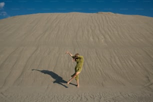 Une femme en robe verte debout dans le sable