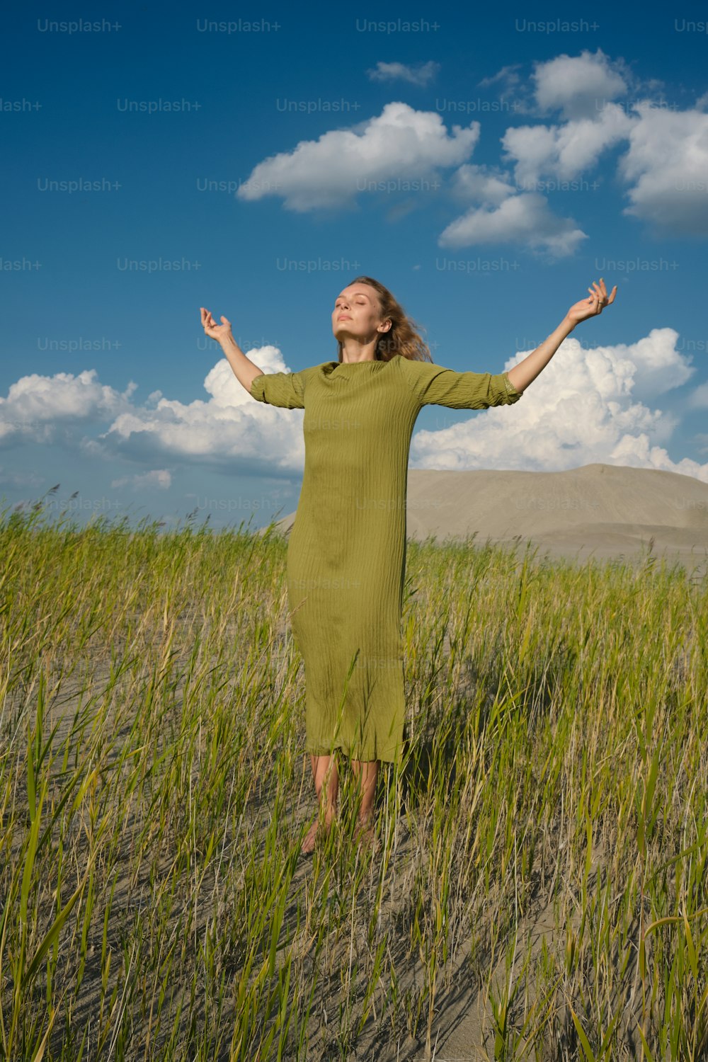 a woman standing in a field of tall grass