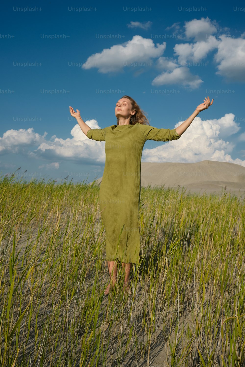 uma mulher em pé em um campo de grama alta