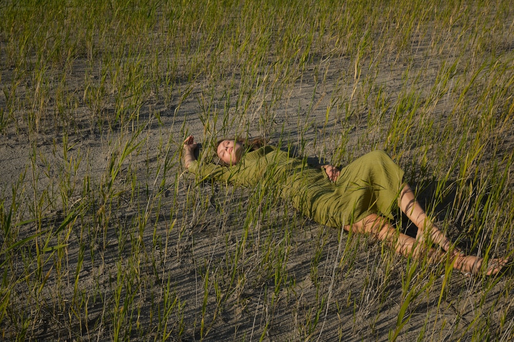a man laying in a field of tall grass