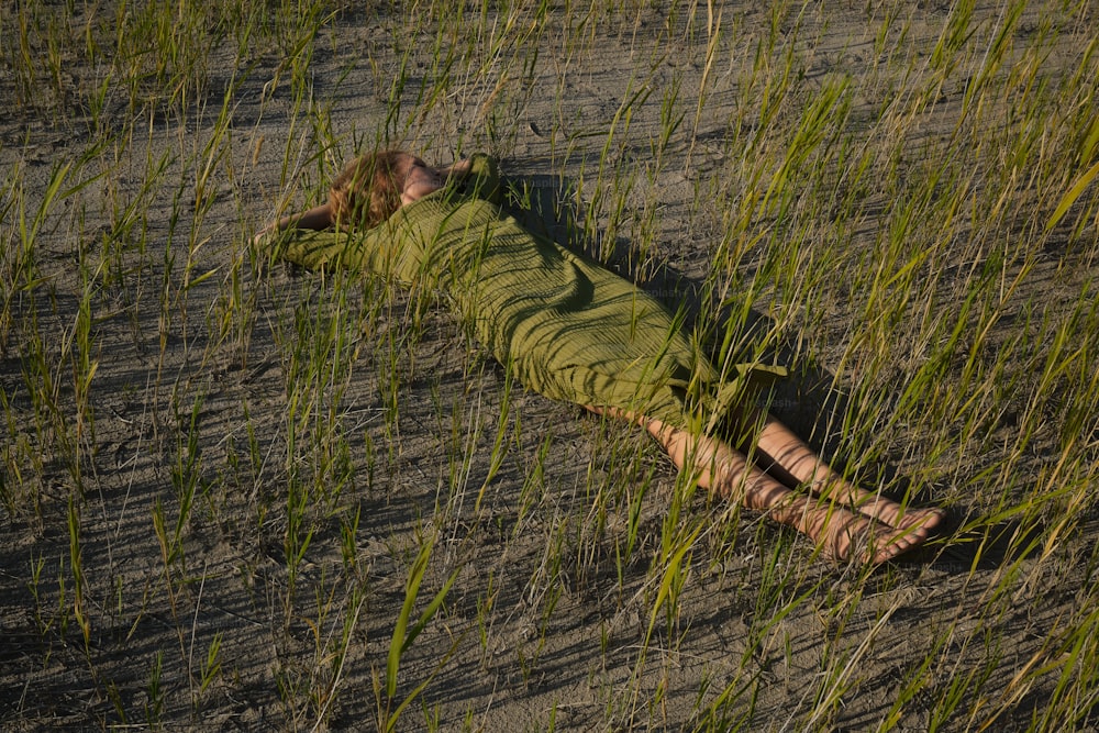 a person laying in a field of tall grass