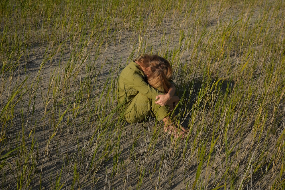 una persona seduta in un campo di erba alta