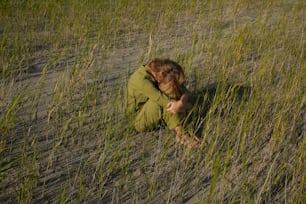 a person sitting in a field of tall grass