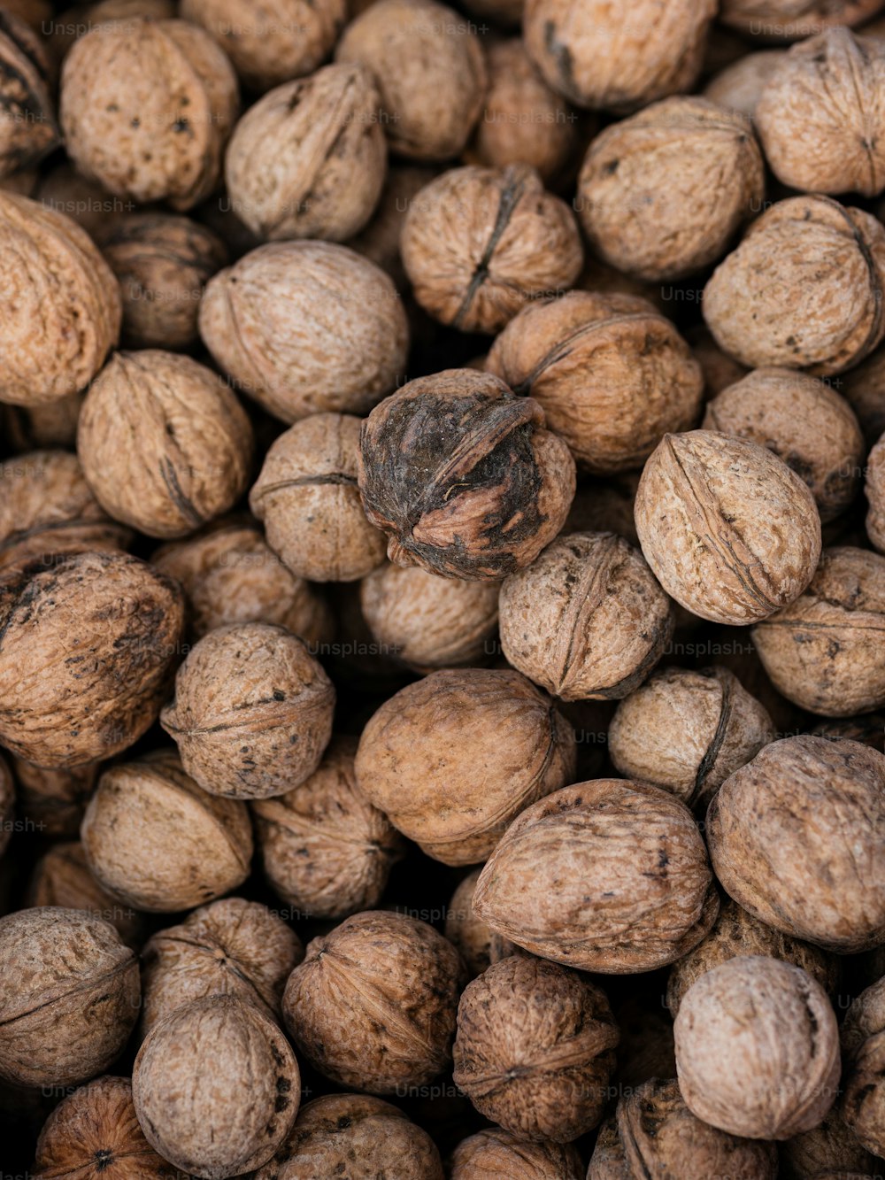 a pile of walnuts that are brown in color