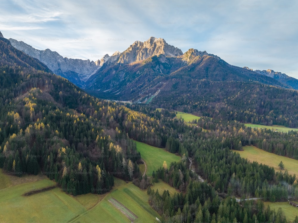eine Luftaufnahme eines Gebirgszuges mit einem Tal im Vordergrund