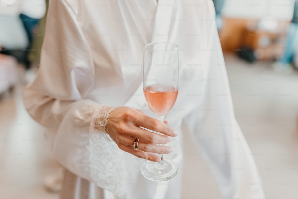 Un primer plano de una persona sosteniendo una copa de vino
