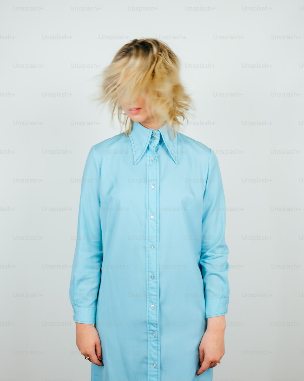 a woman with blonde hair wearing a blue shirt dress