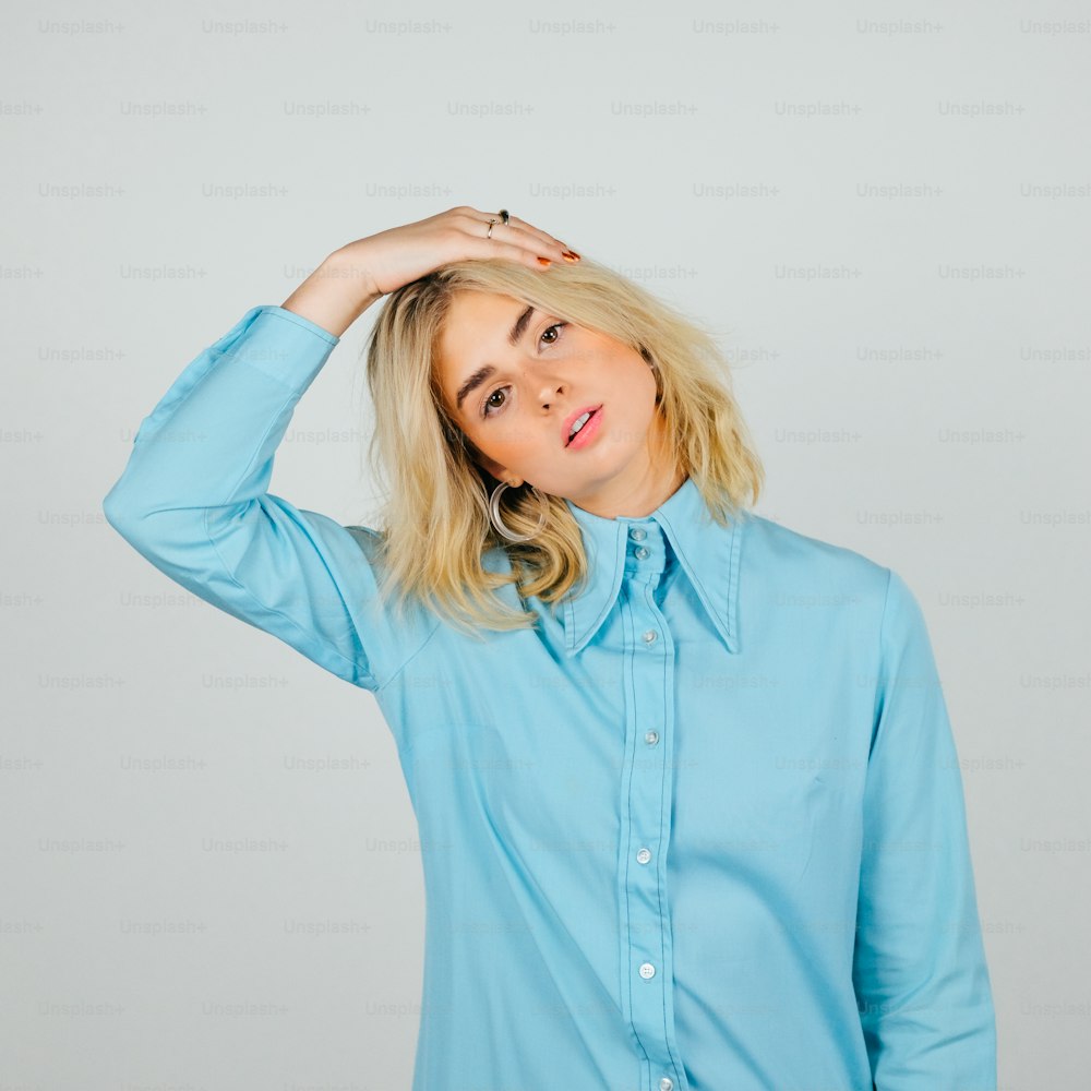 a woman in a blue shirt is posing for a picture