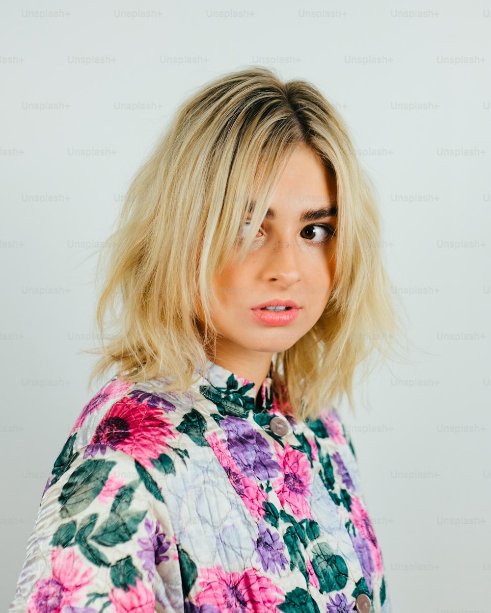 a woman with blonde hair wearing a floral shirt
