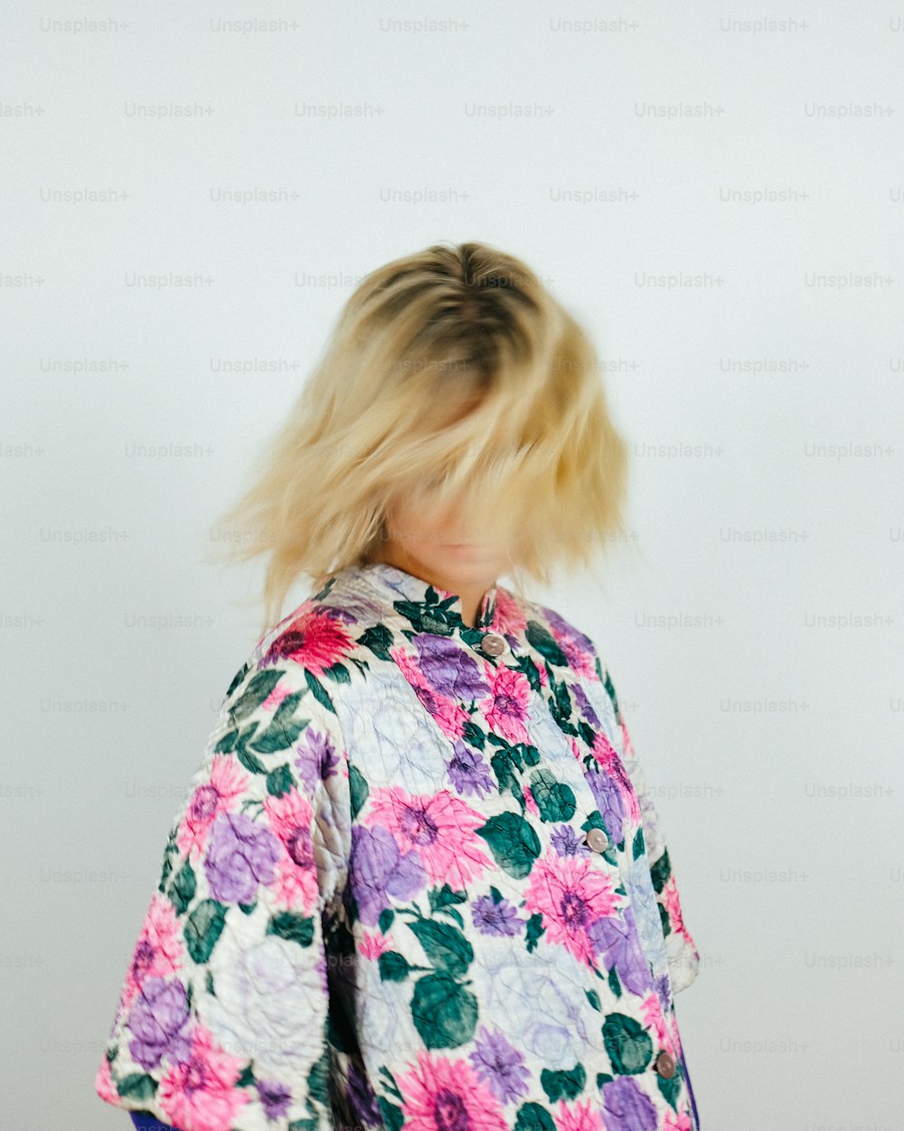 a woman with blonde hair wearing a floral shirt