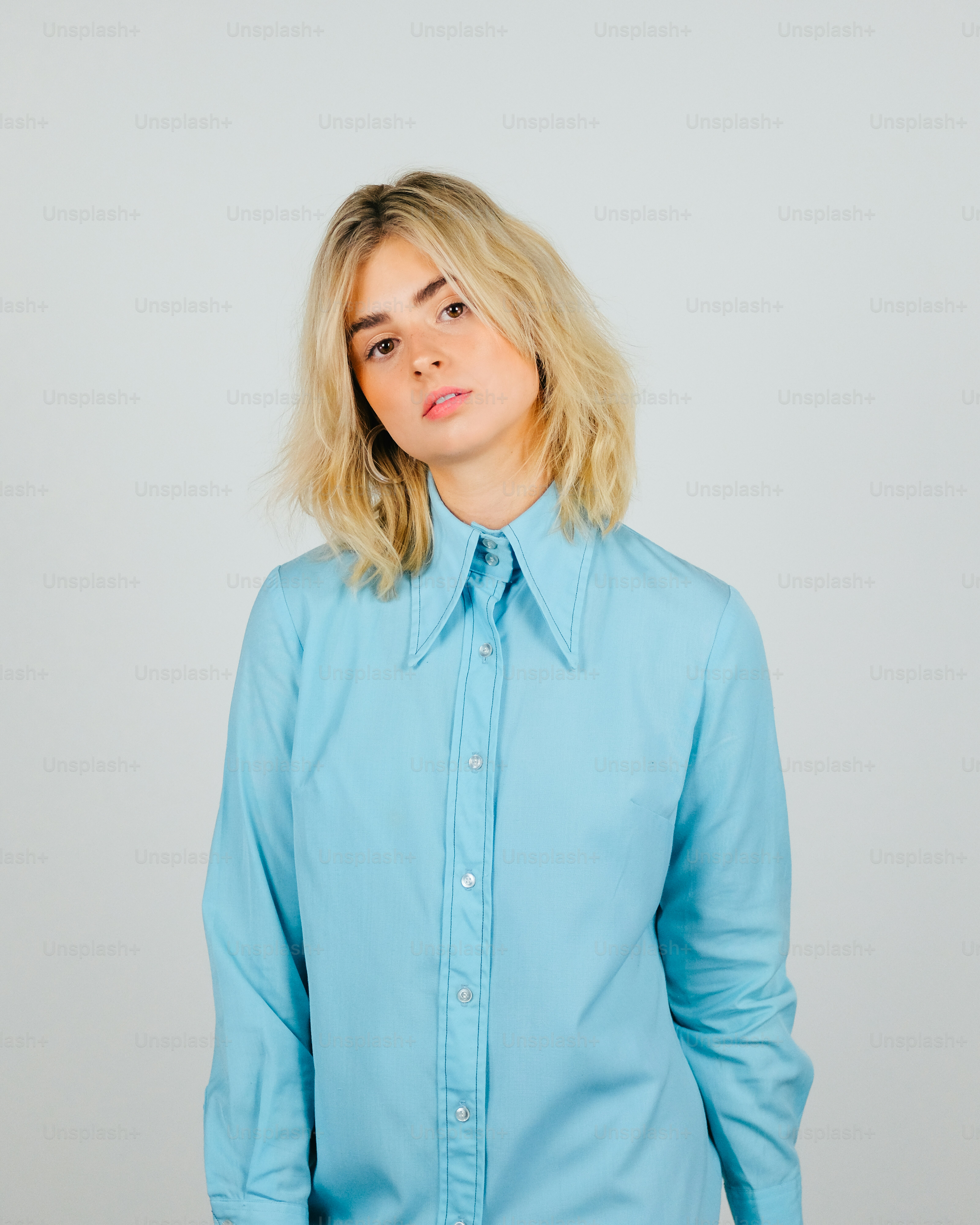 Una mujer con cabello rubio con una camisa azul