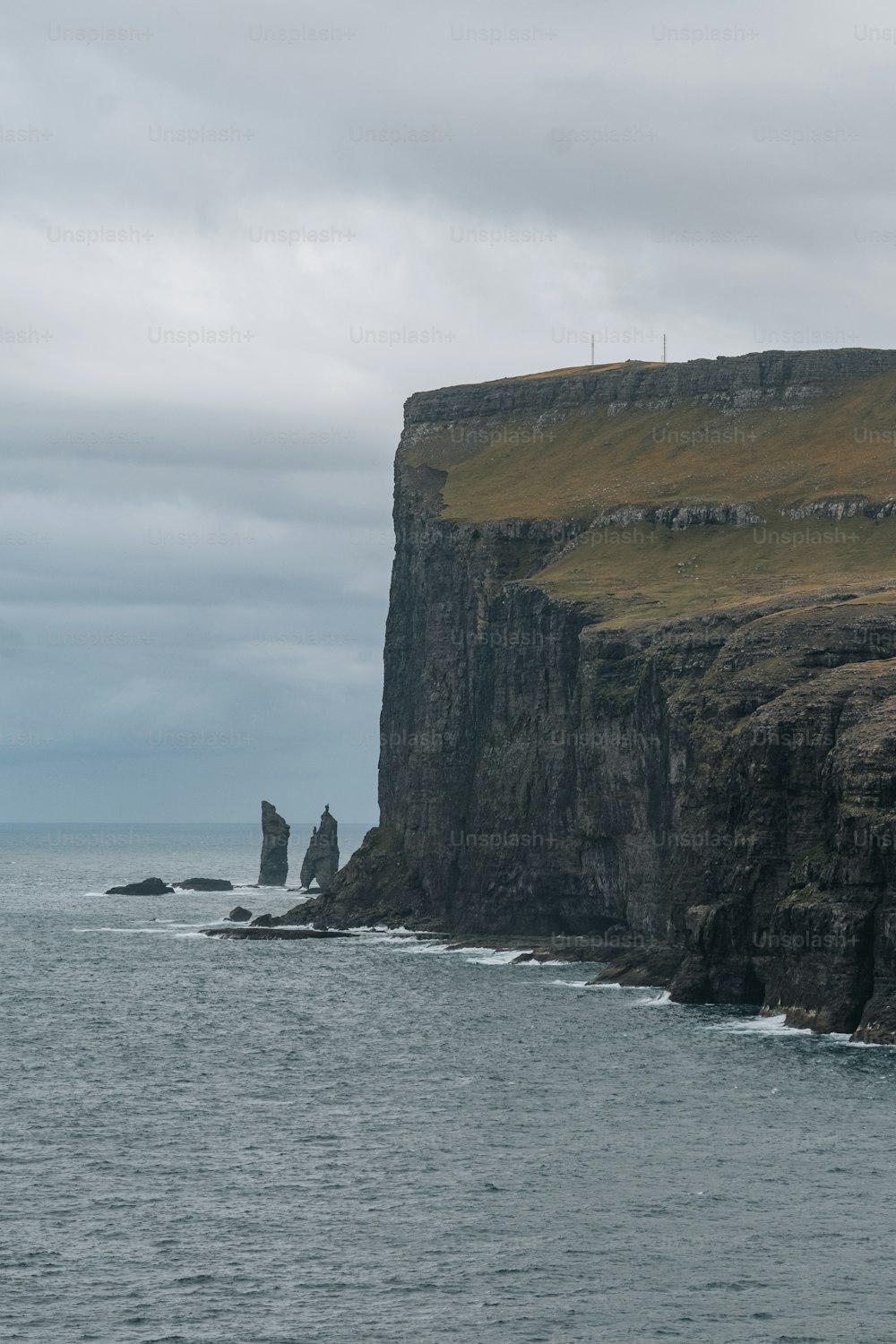 a large body of water next to a rocky cliff