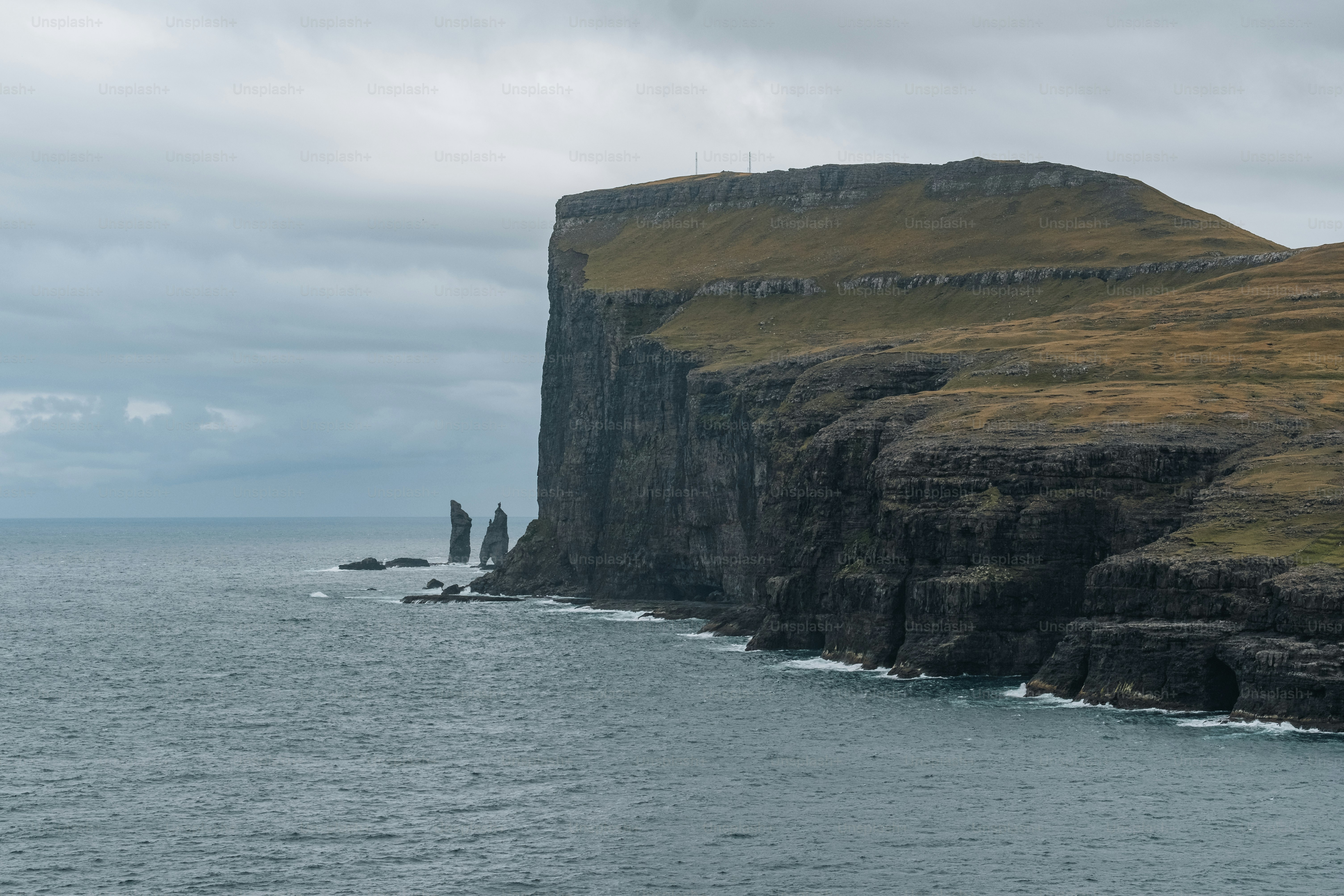 a large body of water next to a rocky cliff