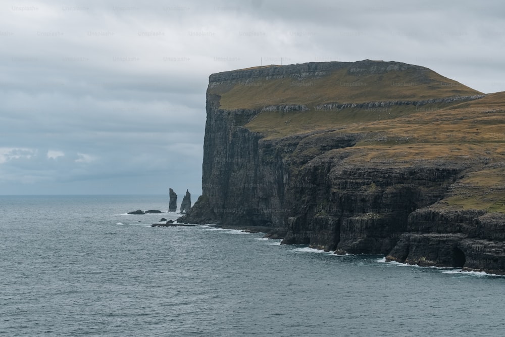 a large body of water next to a rocky cliff