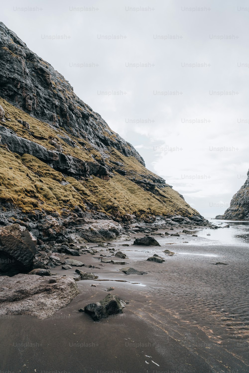 Una playa de arena junto a un acantilado rocoso