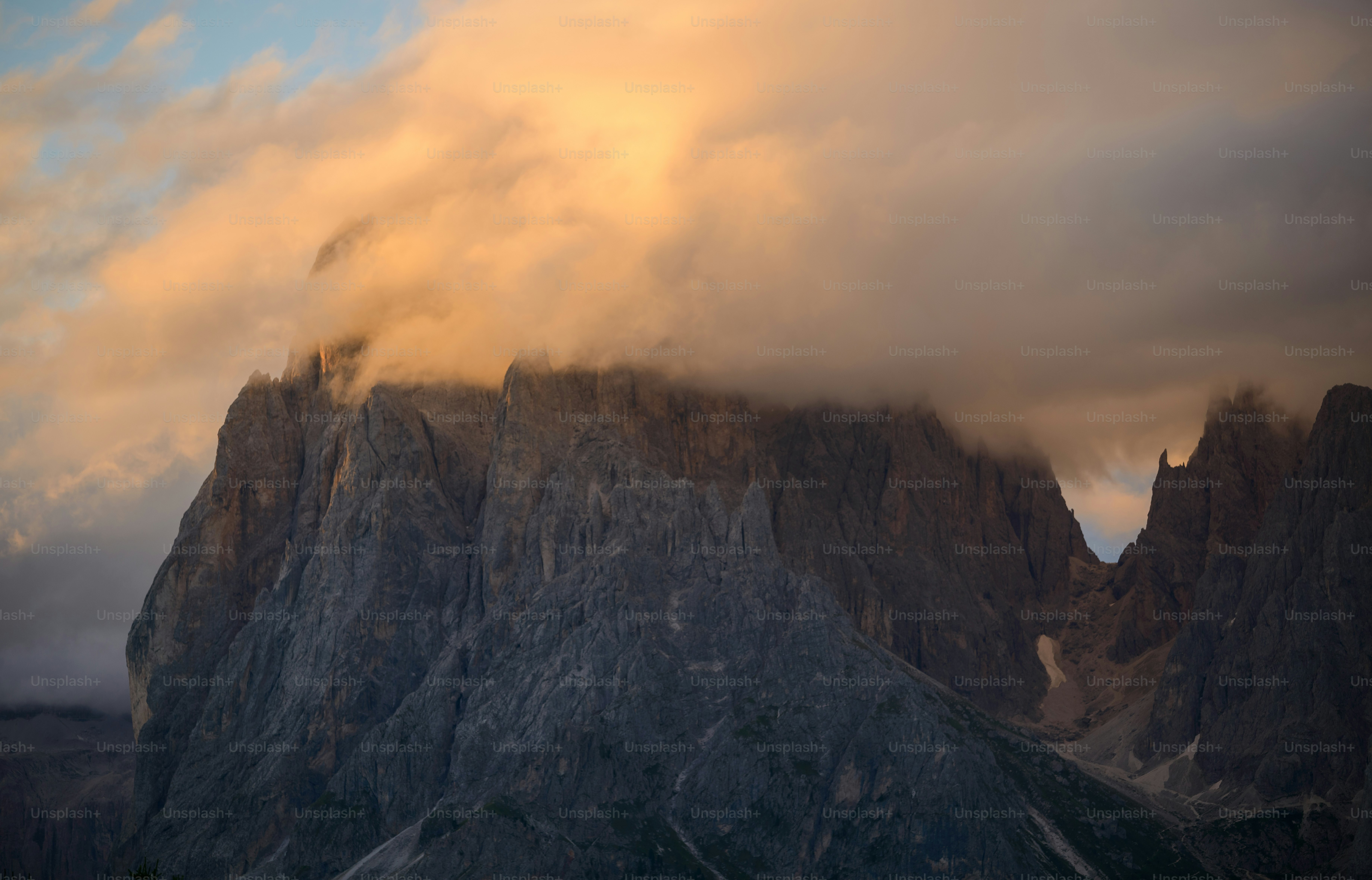 a very tall mountain with some clouds in the sky