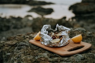 una tabla de cortar de madera cubierta con comida encima de una roca