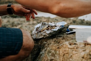 a person reaching for a piece of food on a rock