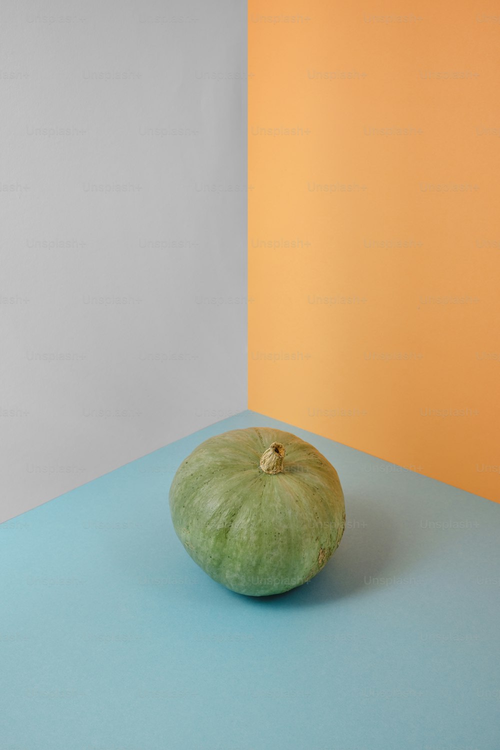 a green apple sitting on top of a blue table