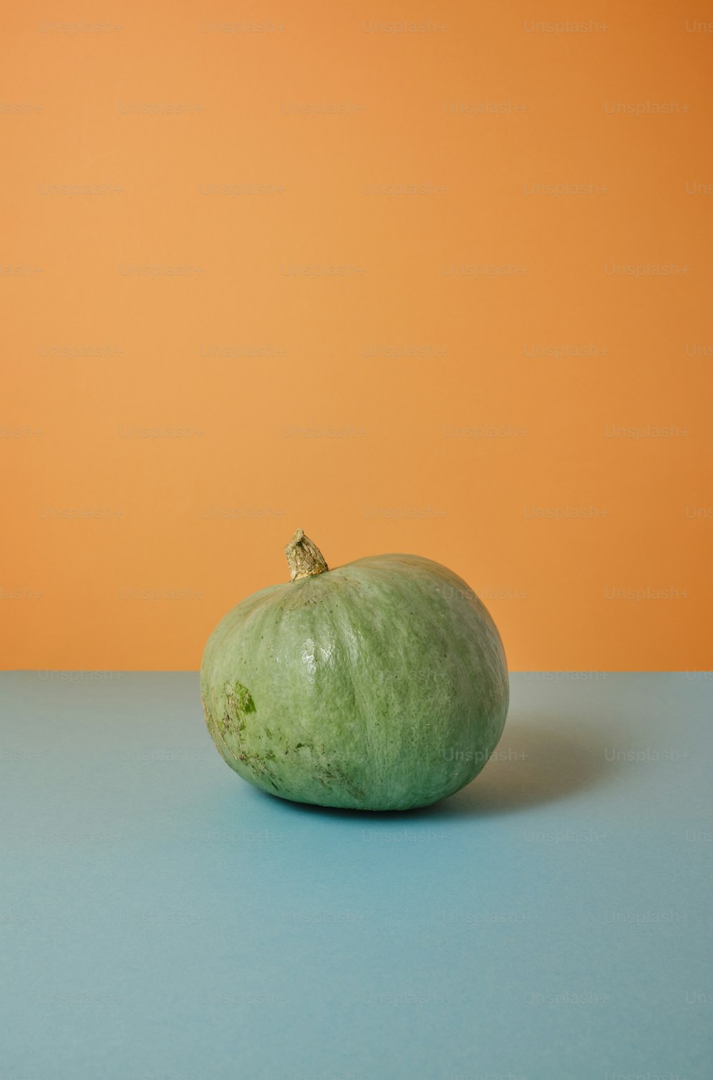 a green apple sitting on top of a blue table