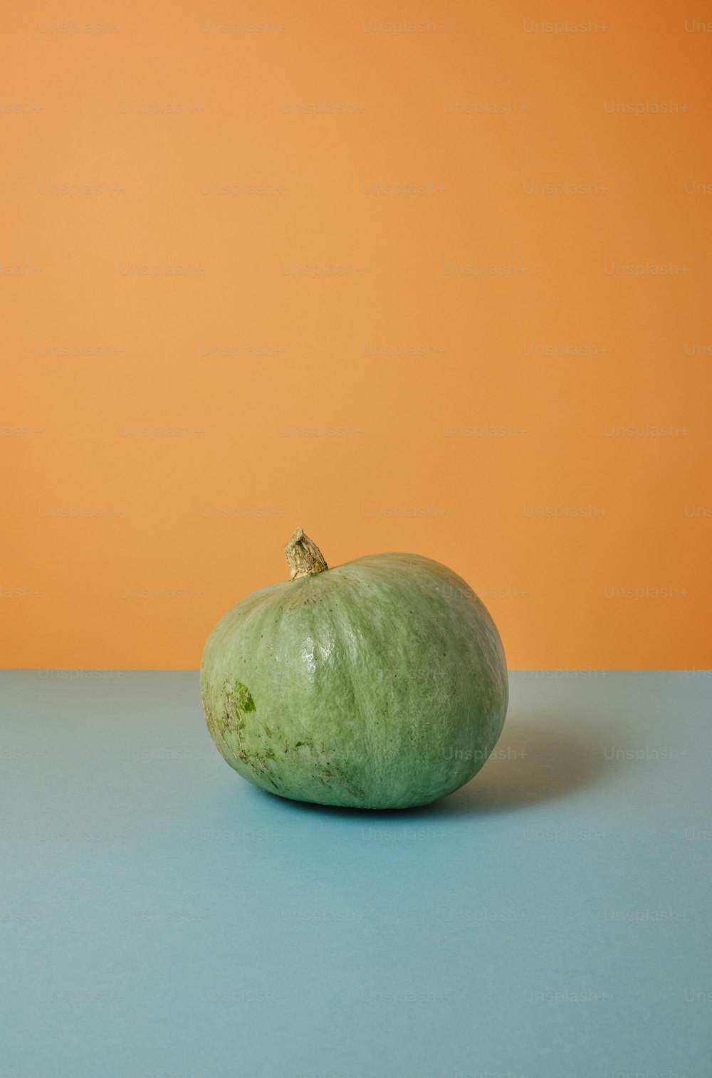 une pomme verte posée sur une table bleue