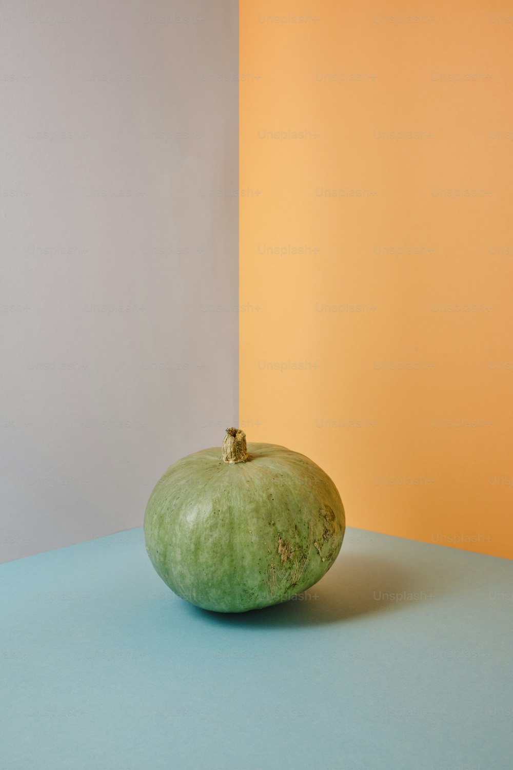 a green apple sitting on top of a blue table
