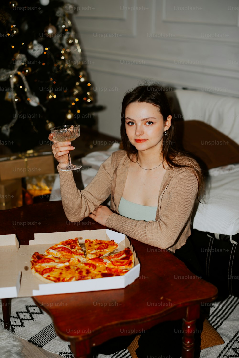 a woman sitting at a table with a pizza in front of her