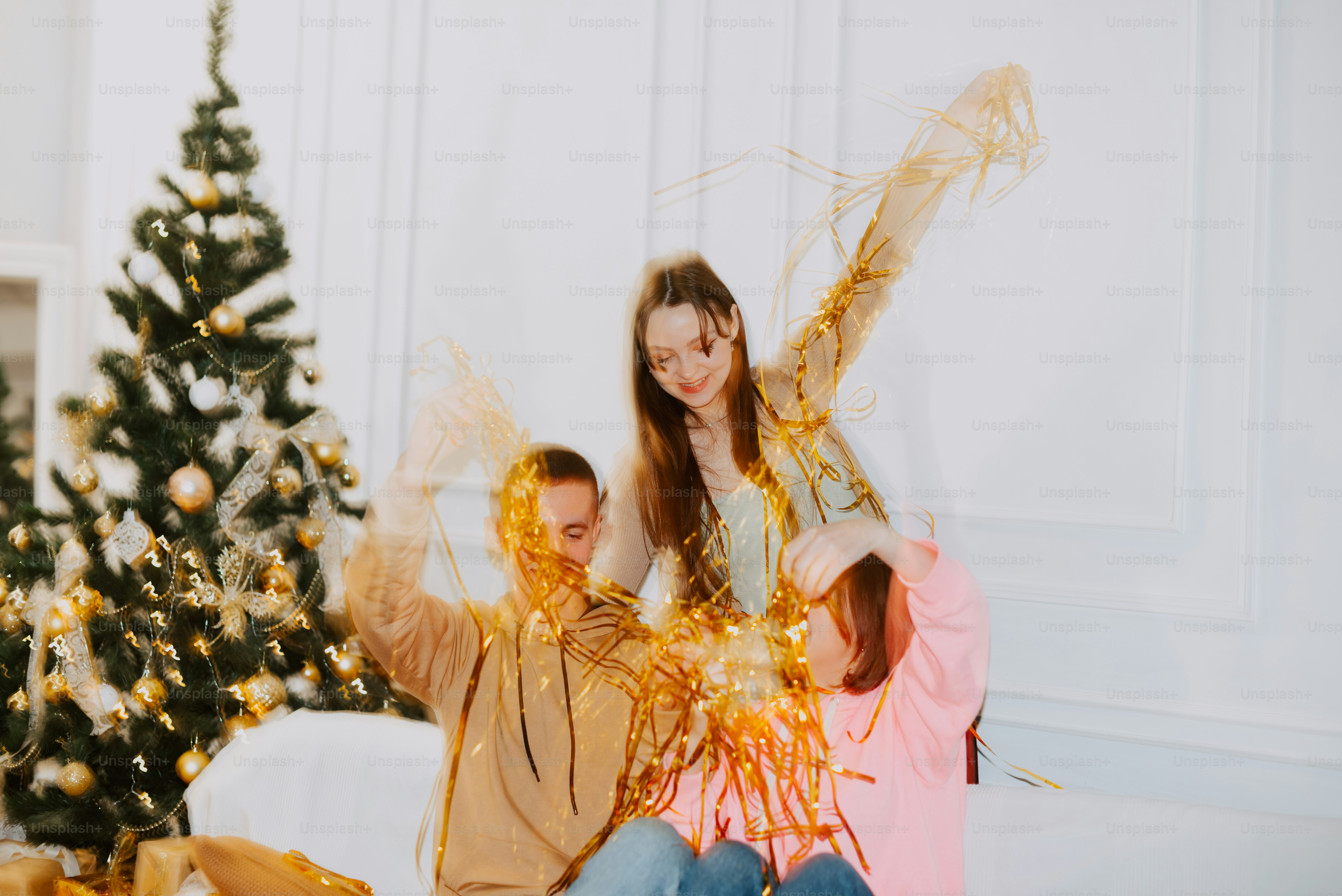 Ein Mann und eine Frau sitzen neben einem Weihnachtsbaum