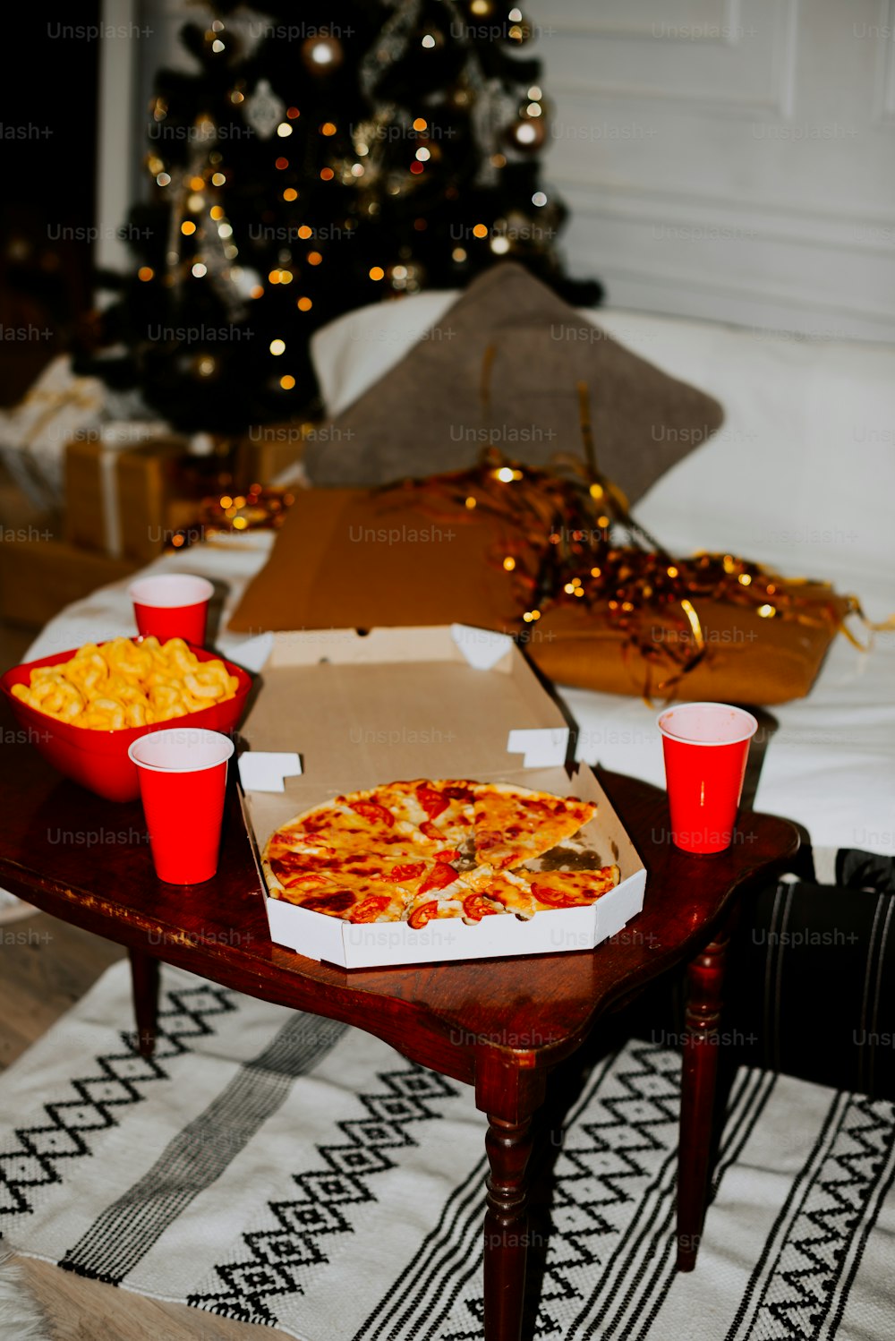 Una mesa cubierta con cajas de pizza y tazas rojas