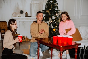 Um grupo de pessoas sentadas ao redor de uma árvore de Natal