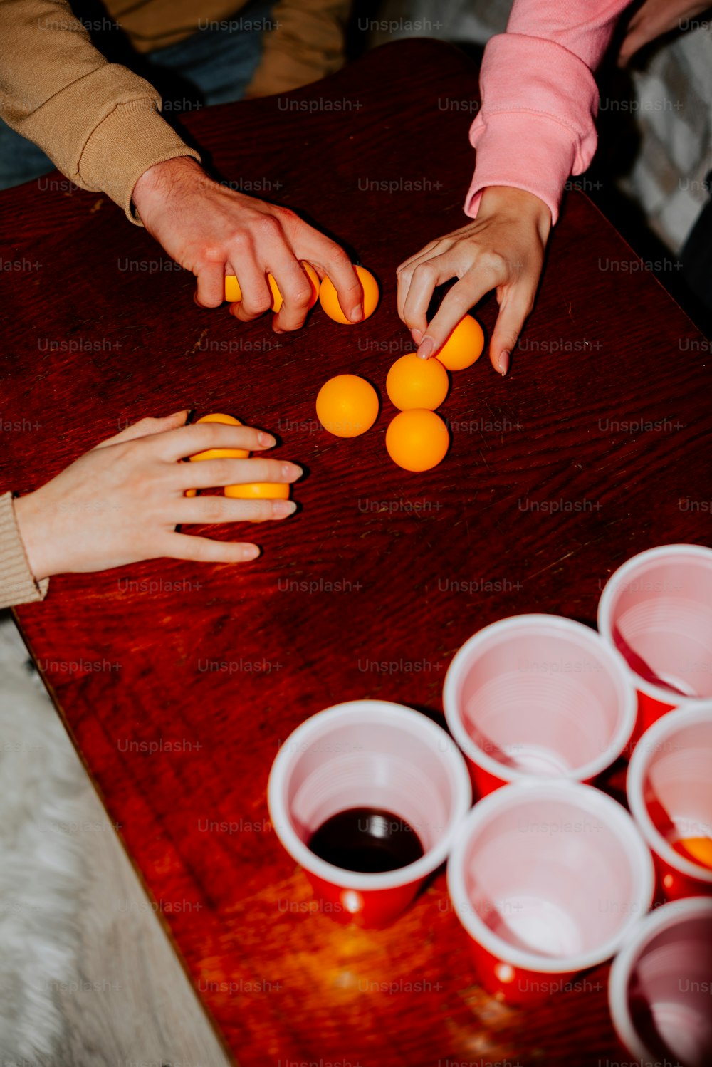 a group of people sitting around a table with oranges